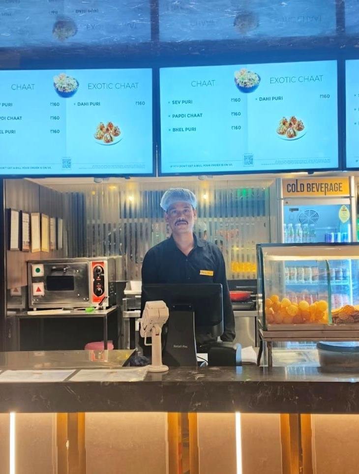 Café Magic team member at a chaat counter inside a cinema